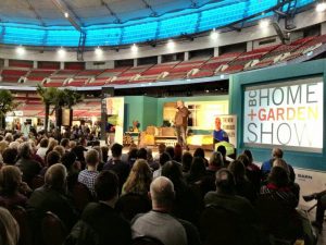 Speaker on stage in front of a crowd at the National Home Show